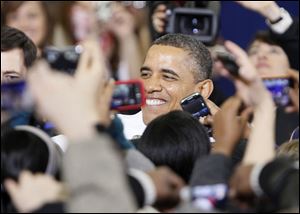 President Barack Obama greets the crowd after speaking at the Al Glick Field House at the University of Michigan in Ann Arbor, Friday.