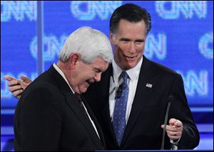 Newt Gingrich and Mitt Romney chat during a break in Thursday's debate. Support for Mr. Gingrich has slipped.