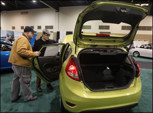Ken Klear, left, and Ralph Zychowicz look over a Ford Fiesta during the auto show in SeaGate Convention Centre in downtown Toledo. 