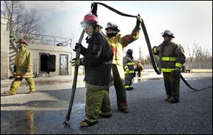 Toledo Maritime Academy seniors Melaine Hileman, left, Taylor Mundy, and Daryl Winfree take part in a fire-training exercise.