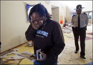 Second grade teacher Monica Finley cries Tuesday after retrieving personal photos from Center Point Elementary School in Center Point, Ala., that was heavily damaged by a tornado Monday.