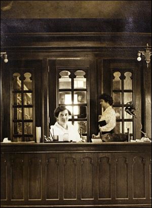 Wood paneling formed the front of a desk at the library early in its existence, and the desk’s arches were echoed in a door behind it.