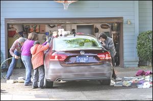 From left, Neil Flynn, Patricia Heaton, Atticus Shaffer and Charlie McDermott are shown in a scene with a Volkswagen Passat in the comedy series 