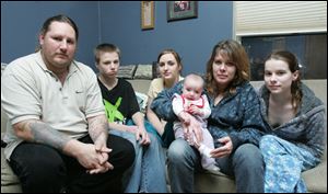 William Erb III sits with members of his East Toledo household Billy Erb, 17, Ashley Erb, 16, Stacy Erb holding granddaughter Sierra Kramer, and Christine Brooks, 19.