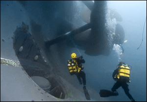 Firemen scuba divers check one of the propellers of the luxury cruise ship Costa Concordia that run ashore off the Tuscany island of Isola del Giglio, Italy, in this photo released by the Italian Fire Brigade, Vigili del Fuoco.