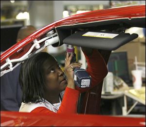 An auto worker assembles parts on the 2013 Dodge Dart at the Chrysler Plant in Belvidere, Ill.