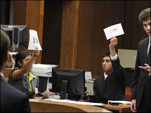 Sylvania Southview student Clement Dupuy, right, is timed as he questions a "witness" during the Lucas County district mock trial competition at the Toledo Municipal Court in Toledo, Ohio.
