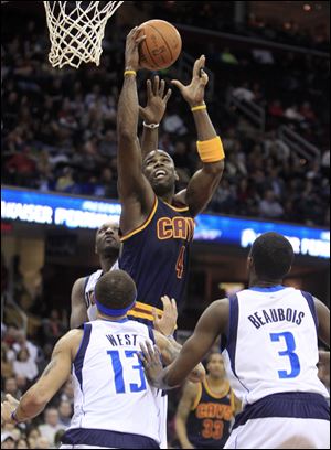 Cleveland Cavaliers' Antawn Jamison (4) shoots over Dallas Mavericks' Delonte West (13) and Rodrigue Beaubois (3) in the second quarter in an NBA basketball game Saturday.