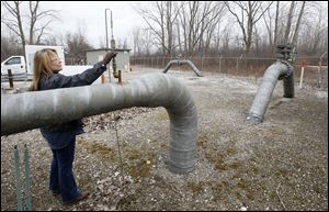 Diana King of Columbia Gas closes a valve at the Maumee Gate natural gas pipeline intersection network site. Columbia Gas official Mike Anderson said that the last time prices were this low, supplies were dwindling. But that's not the case this time, he said.
