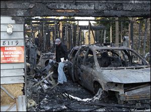 An investigator walks through the garage area in the rubble of the home in Graham, Wash., where Josh Powell and his two sons were killed Sunday in what police said appeared to be a deliberately set fire. 