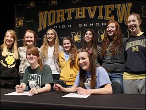 Northview High School cross country teammates Maureen Dean, seated left, and Alison Work, seated right, pose with teammates after sign their national letters of intent to attend their respective colleges, during a ceremony at Northview.  Dean will attend Ohio University and Work will attend Grand Valley State.  Teammates standing from back left are Abby Masters, Katelyn Work, Robin Foster, Laura Judge, Mallory Small, Morgan Vince, Esther Haviland.