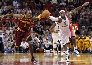 Cleveland Cavaliers' Antawn Jamison (4) and Miami Heat's LeBron James (6) chase a loose ball during the first half of an NBA basketball game in Miami, Tuesday.