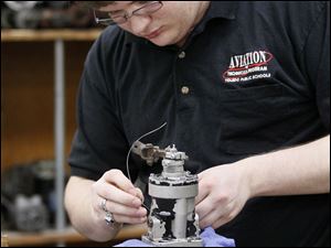Leonard Kaczmark II, 18, works on the safety wiring for a propeller governor at the Aviation Center at Toledo Express Airport.