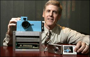 Steven J. Sasson, then-project manager for Eastman Kodak Co., shows the prototype digital camera he built in 1975, left, and Kodak's EasyShare One at the firm's headquarters in 2005. Kodak said Thursday it no longer will make digital cameras or pocket video cameras.
