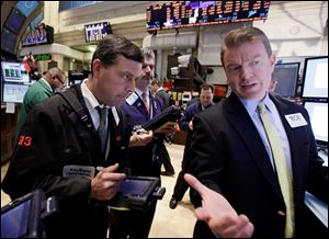 Specialist Michael O'Mara, right, works on the floor of the New York Stock Exchange. 