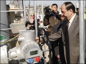 Iraq's Prime Minister Nouri al-Maliki, right, symbolically opens the valve of a new oil export terminal in the Persian Gulf, southern Iraq, Sunday.