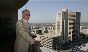Ed Rhodes, a retired school principal, enjoys the view from his 15th-fl oor condo near Dayton’s performing arts center.