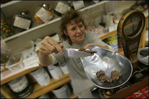 Marge Klein, owner of the Peanut Shoppe in Akron, operates ‘day to day’ but plans to stay put until developers fi nish all of the projects to see if they attract more customers downtown.