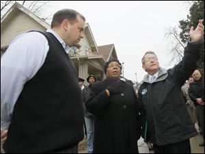 Lucas County Treasurer Wade Kapszukiewicz, left, Toledo Councilman Paula Hicks-Hudson, center, and Ohio Attorney General Mike DeWine tour properties on Mentor Drive in North Toledo.