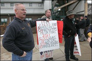 Toledo firefighter James Ferguson holds a sign during Thursday's protest on South Erie. Representatives of firefighters Local 92, the city's main firefighters union, and the city are set to meet again in March. 