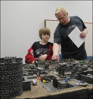 Aiden Gray, 12, of Grand Rapids, Mich., is assisted by Mike McKown of Mansfield, Ohio.