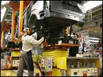  Workers attach the rear axle with the help of a machine at Chrysler's Toledo North Assembly. Employers will seek more workers with higher skills than just having a strong back, and that includes working with computers.