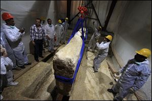 An Egyptian and Japanese team of scientists use a pulley system to lift the first of 41 16-ton limestone slabs to reveal fragments of the ancient ship of King Khufu next to the Great Pyramid of Giza, Egypt, June, 2011.