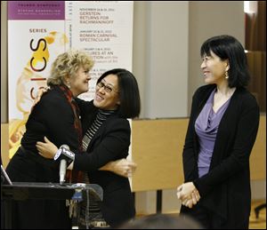 Amy Chang, right, watches as Kathy Carroll, president and CEO of the Toledo Symphony, embraces Yuan Xiaohong of the Dashing Pacific Group,   following an announcement that they would sponsor a trip to China for the Toledo Symphony.