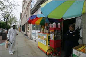 Karen Arranz, right, chats with a customer at her lemonade stand in downtown Youngstown. Her sales, like the city, are going through tough times but will survive and thrive, she predicts