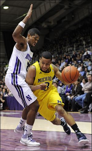 Michigan's Trey Burke, right, drives around Northwestern's JerShon Cobb, left, during the first half of an NCAA college basketball game in Evanston, Ill., Tuesday.