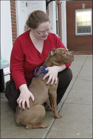 Lucas County Dog Warden Julie Lyle pets Teddy, a 6-month-old 'pit bull' that she took for a walk. She says 'pit bulls' still will be killed unless takers are found for them.