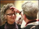  Joan Fothergill, left, from Toledo, receives ashes from Rev. Elizabeth Hoster, right, during the the Ash Wednesday service at Trinity Episcopal Church.
