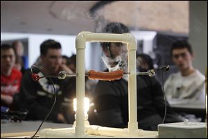 A hot dog sizzles as it is cooked with electrical energy. The event's goal was to entice participants to consider engineering-based careers as the number of students approaching the discipline declines.