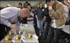 Chris Ackerman of SSOE Group judges the Lego castle competition as students from area high schools watch during the Engineer for the Day program at SSOE's Toledo headquarters.