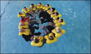 Members of the Megado frequent fliers group float in a circle during a water aircraft landing emergency exercise at the American Airlines training facility in Fort Worth, Texas.