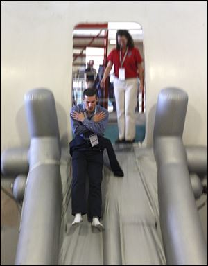 Eric Mueller jumps down an emergency exit slide during an exercise at the American Airlines training facility in Fort Worth, Texas, during the MegaDo event. Mr. Mueller of Los Angeles said that the safety card isn't 'supposed to be a comic book of things you want to try, but it all just looks cool.'