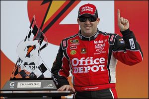 Tony Stewart poses with the trophy after winning the first of two NASCAR Daytona Gatorade Duel 150 qualifying auto races in Daytona Beach, Fla., Thursday.