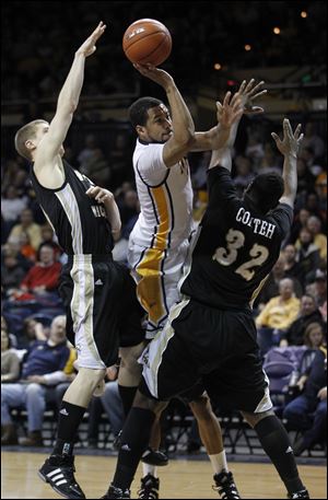 Dominique Buckley shoots between Western Michigan's Brandon Pokley, left, and Muhammed Conteh. The Rockets are 15-14 and tied for second in the MAC West with a 6-8 record.