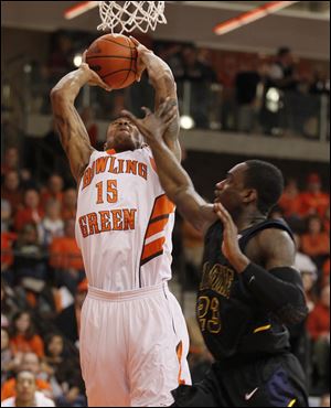 Bowling Green's A'uston Calhoun dunks the ball while being defended by Kent State's Patrick Jackson.