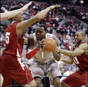 Wisconsin's Jordan Taylor, right, and Ryan Evans trap Ohio State's Deshaun Thomas (1) during the second half of an NCAA college basketball game, Sunday,