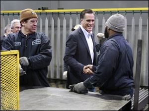 Mitt Romney greets workers Horacio Abadia, left, and Maurice Manley, right, at American Posts during a campaign stop in Toledo.