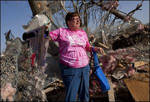 Patty Ferrell, of Herod, Ill., is overcome with emotion after finding nursing scrubs on a hanger that belonged to her daughter, Jaylynn Ferrell, 22, who was killed in a tornado that struck Harrisburg, Ill., on Wednesday. The tornado destroyed the duplex where Jaylynn Ferrell had lived.