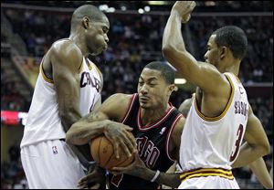 Chicago Bulls' Derrick Rose, center, drives between Cleveland Cavaliers' Antawn Jamison, left, and Ramon Sessions (3) in the first quarter Friday night.