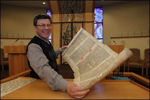 Cantor Ivor Lichterman holds the scroll of the Book of Esther. It does not contain the name of God and thus is the only book in the Jewish Bible that the faithful touch. Scroll handles are used for all others.