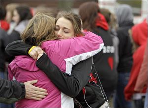 Two students hug on the town square in Chardon, Ohio before marching to the high school to honor the three students who were killed Monday.