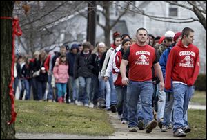 Hundreds of students, along with their parents, walk to Chardon High School in honor of the three students shot and killed on Monday. Classes resume a full schedule on Friday.