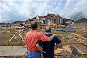 Jerry Vonderhaar, left, comforts Charles Kellogg after severe weather hit the Eagle Point subdivision in Limestone County, Ala. on Friday.