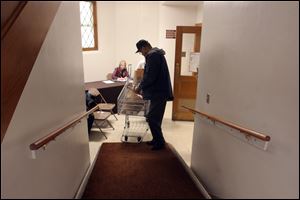 Roderick Wright packs up the food he has gathered from the Feed Your Neighbor program at Augsburg Lutheran Church in West Toledo.