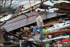 A man walks around a destroyed house Friday looking for belongings in Henryville, Ind., after a series of powerful tornadoes tore through southern Indiana, in this photo provided by SWAT Chasers.