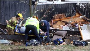Walton Ky. firefighters rescue a woman who was trapped under debris behind a house Friday in Boone County, Ky.
